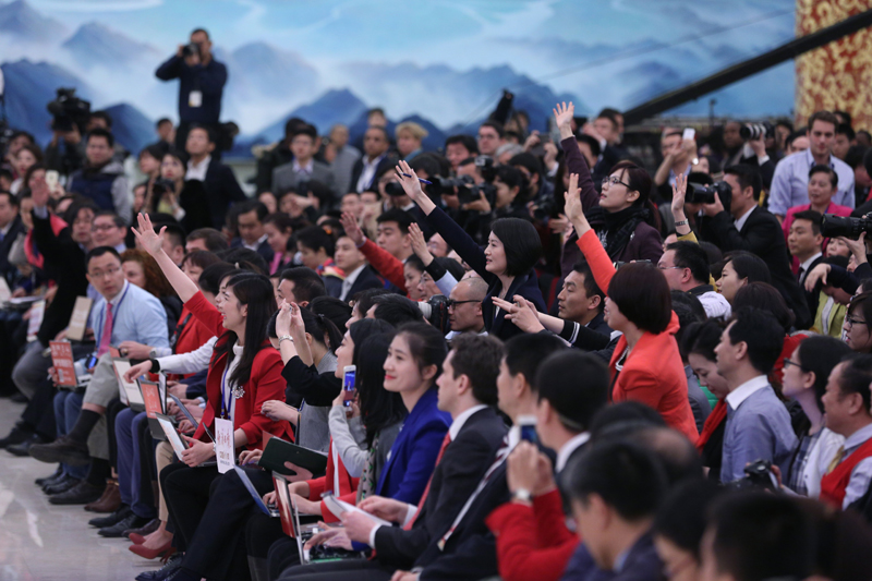 3月15日，國務院總理李克強在北京人民大會堂與中外記者見面，并回答記者提問。這是記者舉手爭取提問機會。 新華社記者 才揚 攝