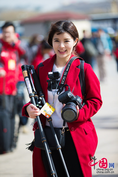 2016年兩會，人民大會大堂前，一位笑容燦爛的紅衣女記者正步入大會堂。中國網(wǎng) 鄭亮 攝